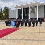 Trzech strażaków niesie sztandar w tle strażacy stojący na baczność na Placu Fryderyka Chopina w Puławach.