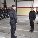 Naczelnik składa meldunek Komendantowi Powiatowemu Państwowej Straży Pożarnej w Puławach w tle strażacy ochotnicy stojący na baczność.
