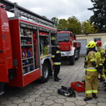 Samochód strażacki z otwartymi skrytkami ze sprzętem ratowniczym.