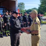 Komendant ściaska dłoń awansowanemu.