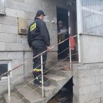 Strażacy Ochotniczej Straży Pożarnej przekazują ulotkę starszej kobiecie.