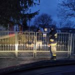 Strażak Ochotniczej Straży Pożarnej przekazuję ulotkę starszej kobiecie.
