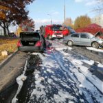 Dwa uszkodzone samochody osobowe podczas zderzenia czołowego na ulicy Gościńczyka w Puławach. W tle samochód strażacki.